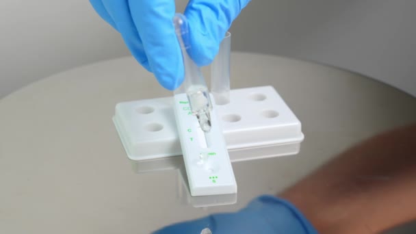 人はコロナウイルスCovid 19の検出のために迅速に試験片試験液を滴下する 自宅用の個人用抗原迅速自己テストキット 体外診断用にのみ — ストック動画