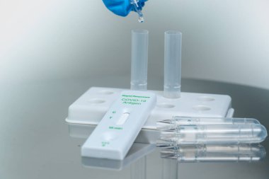 Mavi eldivenli erkek hemşireye yakın çekim tampon tüplerine test reaktörleri bırakıyor. Burnundan alınan örneklerde Covid 19 hayati antijenin nitel tespiti. Kendini test etmek için.. 