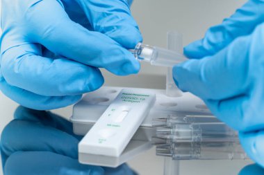 Mavi eldivenli şahıs evde COVID-19 hızlı test yapar. Sadece tüp bebek testlerinde kullanılır..