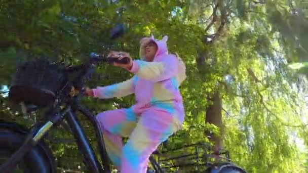 Cyclist Unicorn Costume Riding Electric Bicycle Green Urban City Area — Stockvideo