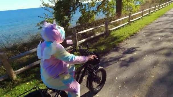 Cyclist Unicorn Costume Riding Electric Bicycle Green Urban City Area — Stock Video