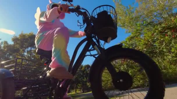 Woman Funny Crazy Colourful Unicorn Dress Riding Electric Bicycle Smiling — Stock Video