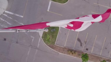 Flag of Canada flying against a summer blue sky. Canadian flag waving on the wind. Canadian flag with maple leaf on the pole slow motion movement.