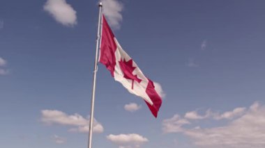 Happy Canadian citizen patriot concept. Canadian flag at wind, blue cloudy sky and golden hour sun.