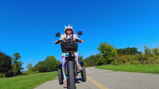 Жінка Смішному Божевільному Барвистому Одязі Єдиноріг Їде Електричному Велосипеді Посміхається — стокове відео