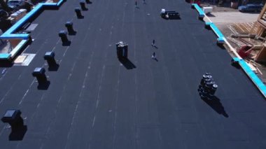 Güneşli bir günde inşaat halindeki yeni apartman. Düşük katlı konut inşaatı projesi. Kontrplak çatının ve duvarların hava denetimi çerçevesini sanayi kalasıyla kaplıyor..