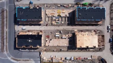 Yeni konak inşaatı alanındaki hava teftiş manzarası. Ahşap bina ve inşaat halindeki beton bodrumlar. Yeni evleri olan inşaat alanı.