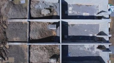 Yeni konak inşaatı alanındaki hava teftiş manzarası. Ahşap bina ve inşaat halindeki beton bodrumlar. Yeni evleri olan inşaat alanı.