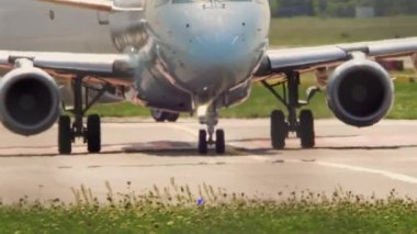 Hava otobüsü güneşli bir günde havaalanından geçiyor ve sisli bir sis var. Tanımlanamayan yolcu uçağının ön görüntüsü. Motorları kalkışa yaklaşıyor. Turizm ve seyahat.