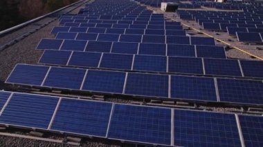 Solar power station panels on the school roof building at golden hour. Green energy at hazy sunset. Set of solar panels plants at college sealing in the evening.