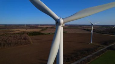 Enerji üretimi için güçlü rüzgar türbininin havadan görünüşü açık mavi gökyüzü ve altın saat. Rüzgar türbinleri temiz sürdürülebilir enerji üreten yel değirmenleri. Yel değirmeni ya da rüzgar türbinleri çiftliği.