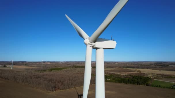 航空機の視野にブレードを持つ大規模な風力タービン 農場のパノラマと青空 風車は緑のエネルギーを生み出す 持続可能な代替エネルギー スローモーション — ストック動画