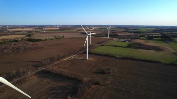 背景に風力タービン発電所の農場と風景のショット 環境工学と再生可能エネルギー 黄金の時間の夕日の風車の景色 — ストック動画