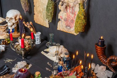 Esrarengiz ve esrarengiz büyücülük hala hayattadır. Sihirli objelerle cadılar bayramı geçmişi. Siyah mumlar, kafatası, kristal taşlar ve cadı için iksir şişeleri. Kuru otlu mistik cadılık arka planı.