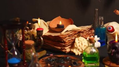 Gizemli büyücülük geçmişi, odak değişimi, cadı aletleri, eski sarı parşömen yıpranmış sayfalar, sihirli ayinler. Cadılar Bayramı teması, keçi çene kemikleri, siyah mumlar, büyüler için kuzgun parmağı