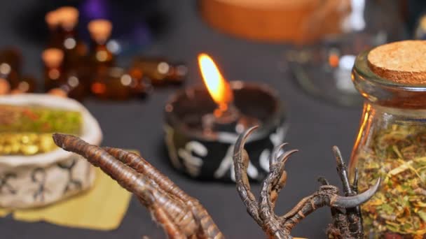 魔法のシンボルを持つカップの中で黒い燃焼キャンドルとウィッチクラフトはまだ人生の焦点シフト ハロウィーンのための密教ゴシックとオカルト魔女の工芸品 様々な魔法の物や儀式の配置 — ストック動画