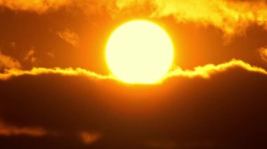 Sinema güneşi kırmızı sarı ve turuncu gökyüzünde batıyor. Sıcak yaz atmosferi sıcak hava dalgasında. Sarı güneş destansı altın saat hızında batıyor. Büyük yuvarlak güneş diskini kapat.