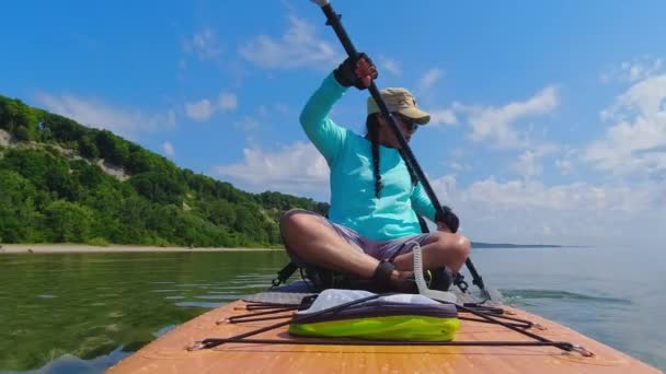 夏休みにウォータースポーツをする女性 アクティブなライフスタイルや観光 暑い日に湖でボード上の女性のパドル 夏のレジャーの間の健康的な活動と旅行 — ストック動画