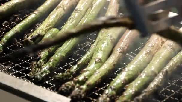 烤肉烤架上的芦笋炒熟了 将新鲜的绿色芦笋或麻雀草放在户外木柴烤架上 用铁金属烤架烤 烤蔬菜 混合蔬菜沙拉 — 图库视频影像