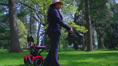 Hareket engelli bir kameraman ya da fotoğrafçı doğanın fotoğrafını çekiyor ve baharın tadını çıkarıyor. Mobilite scooterındaki yarı etnik bağımsız içerik yaratıcısının sinematik çekimi