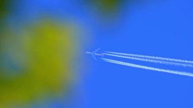 Mavi gökyüzünde parlak beyaz iz bırakan bir jet uçağı. Uçak buharı, Contrails, Chemtracils, ya da Yoğunlaşma Yolu, motorlardan gelen havacılık uçağı emisyonları. Uçaktan CO2 karbondioksit.