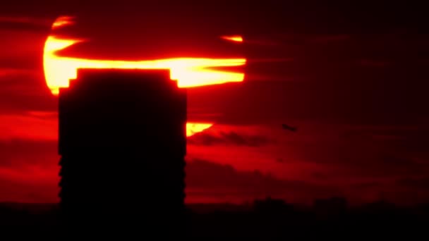 飛行機は赤い壮大な映画の日の出で飛ぶ 劇的な夕日と空を横断する小型旅客機のシルエット 国際輸送飛行旅行 — ストック動画