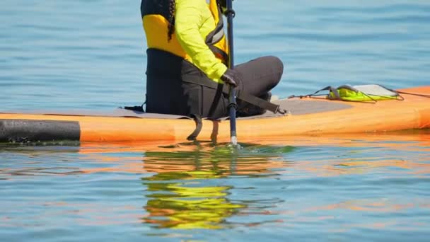 北米の伝統的なスポーツ活動 Supボードのライフジャケットを着た女性がマンチョウ湖水で運動 カナダの晴れた夏の日にパドルSupボードでトレーニングとスポーツ マニトリン — ストック動画