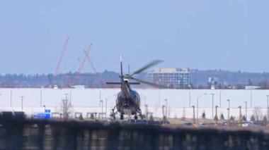 Polis helikopteri şehrin üzerinde uçuyor ve yavaş çekimde gökyüzüne yükseliyor. Suç soruşturması için helikopterdeki polis pilotları Toronto, Ontario, Kanada - 14 Nisan 2023