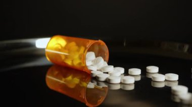 Metal masada oksikodon Opioid tabletleri var, hareket makrosu kapalı. Genel ağrı kesici haplar yazıldı ve kontrol edildi. Oksikodon hapları ve haplar için reçete şişesi..