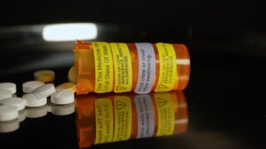Metal masada oksikodon Opioid tabletleri var, hareket makrosu kapalı. Genel ağrı kesici haplar yazıldı ve kontrol edildi. Oksikodon hapları ve haplar için reçete şişesi..