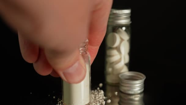 ガラス瓶に貯蔵された粉末状の違法薬物は 薬物乱用を示しています オピオイドとフェンタニルを含む継続的な危機 コンテナに置かれたヘロインまたは粉砕された酸素コドン — ストック動画