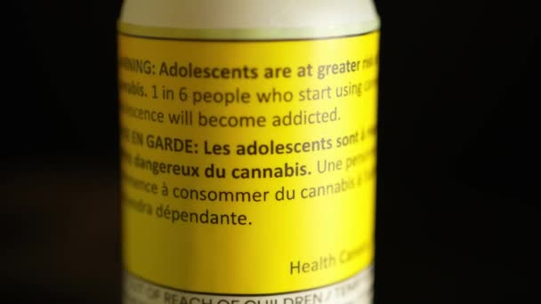 宏观上看 生物多样性公约 大麻油瓶子与加拿大健康警告青少年危害的风险 大麻酚或大麻酚 由大麻草植物制成 具有止痛作用 — 图库视频影像