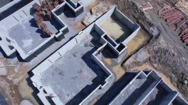 Yeni konak inşaatı alanındaki hava teftiş manzarası. Ahşap bina ve inşaat halindeki beton bodrumlar. Yeni evleri olan inşaat alanı.