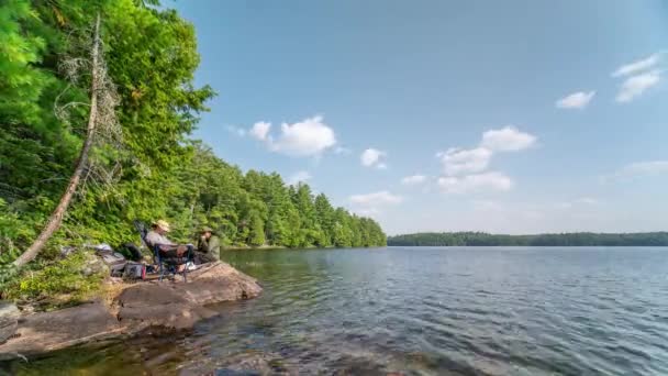 カナダ オンタリオ州サイレントレイクでの釣り時間の経過 アングラーが水にロッドラインを投げ込む フライフィッシング 野生の湖での家族のレジャー 夫と妻は釣りを再開する 夏の趣味と休暇について — ストック動画