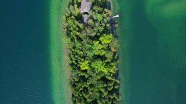 Manitou Gölü 'ndeki sakin suların sessiz cazibesine sahip muhteşem özel adanın havadan görünüşü. Manitoulin Adası 'nın temiz suları küçük adadaki güzel kır evlerini çevreledi..