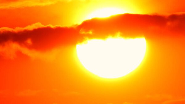 Big bright yellow hot sun disk moves down as sunset. Epic sky and sky line. Amazing orange red yellow colors of the setting sun dusk. Vibrant colors and sun set.