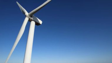 Aerial close up shot of wind mills turbine rotating by the wind and generating renewable green energy. Closeup of a wind turbine during golden hour sunset. Energy alternative and environment ecology.