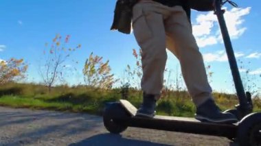 Motorlu scooter kullanan genç birinin benzersiz görüntüsü. Eğlence amaçlı elektrikli şehir aracı. Aksiyon kamerası.