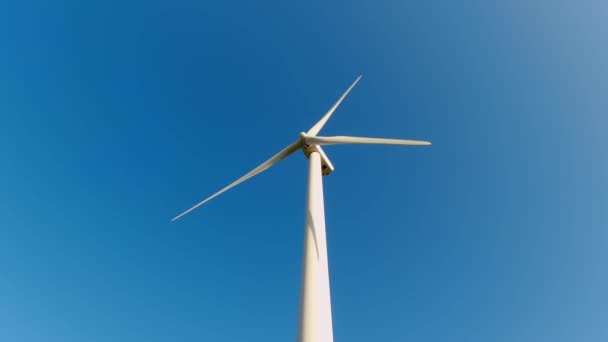 从下方俯瞰强大的风力涡轮机 为能源生产带来晴朗的蓝天 风力涡轮机风力发电机组产生清洁的可持续能源 风车或风力涡轮机农场 — 图库视频影像