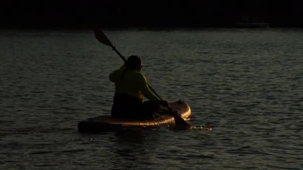Женщина Скользит Доске Время Спокойного Золотого Часа Заката Безмятежном Озере — стоковое видео