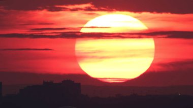 Amerikan şehri, günbatımı güneşi binaların siluetinin üzerinde. Gökdelenler, siluetler ve ufuk çizgisi üzerinde destansı sıcak turuncu güneş batıyor.. 