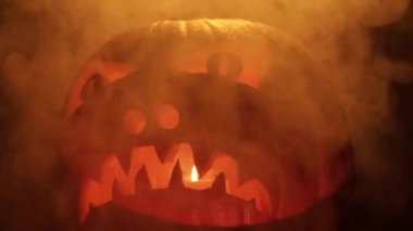 Cadılar Bayramı balkabağı dumanla, mum ışıklarıyla ve karanlık geceyle parlar. Cadılar Bayramı gecesi Jack O Lantern balkabağı. Ruhlar ve şeytanlar.