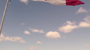Happy Canadian citizen patriot concept. Canadian flag at wind, blue cloudy sky and golden hour sun.