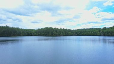 Yoğun çam ormanları ve uzak tehlikeli rotalarla çevrili resimli kayalık turkuaz mavi göl. Sakin suyun destansı drone görüntüsü. Ontario, Kanada 'daki doğal göl manzarası, Crown arazisi..