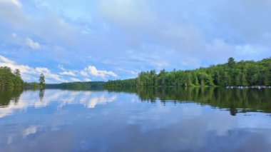 Sessiz Göl 'ün sinematik ve güzel huzurlu manzarası. Ontario, Kanada 'nın kuzeyinde vuruldu. Kuzey Amerika 'daki gölün çekimini yapıyorum. Kuzey gölünde resim gibi gün batımı. Sakin su yansıtan manzara.