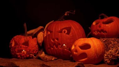 Cadılar Bayramı balkabakları ön bahçe dekorasyonu için karanlık bir düzenleme. Azizler Günü ruhları cehennem ve mistik arka plan, oyulmuş kafalarda yanan mumlar..