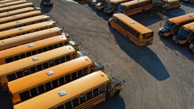 Toronto, Ontario, Canada - September 1, 2022: The parking full of school buses waiting for educational season. Row filled with many school bus ready to pick up students to school. Aerial view.