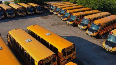Toronto, Ontario, Canada - September 1, 2022: View on parked American buses in Canada waiting for the educational season. Yellow school buses in parking at golden hour. 