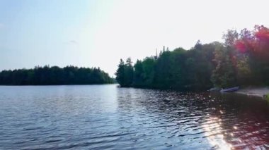 Vancouver, Kanada, Kuzey Amerika 'daki sakin göl panoramik manzarası. Yolculuk sırasında, yaz günü yavaş çekimde, ıssız ve vahşi ormanlarla dolu bir liman. Dağlarda mavi gökyüzü ve beyaz bulutlarla.