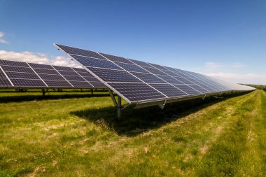 Güneşli yaz gününde panelde fotovoltaik hücreleri olan güneş enerjisi santrali manzaralı güneş çiftliği. Yeşil teknoloji manzarası ve güneşten gelen temiz elektrik üretimi. Karbon ayak izi azalt